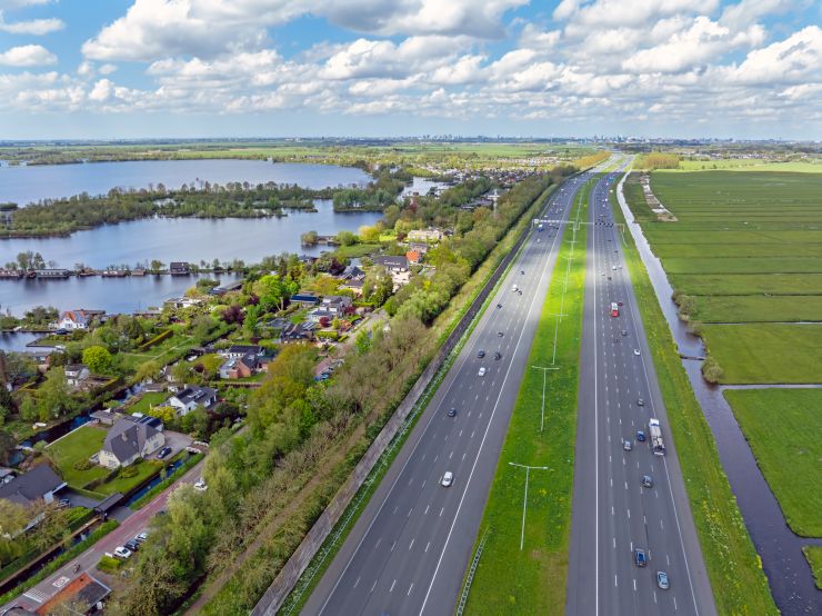 Een luchtfoto van een snelweg die langs een dorp loopt.